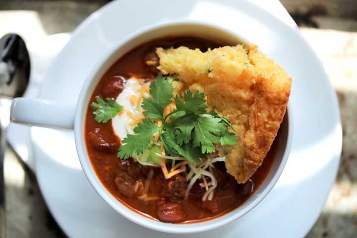 elk chili topped with cornbread and fixins