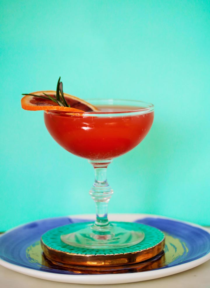 Blood Orange Rosemary Martini served with Blood Orange slice and Rosemary Garnish 