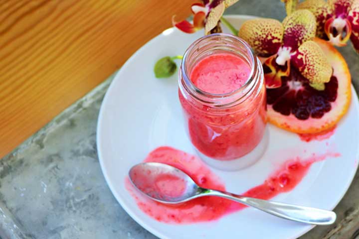 Blood Orange Vinaigrette in mason jar with sliced blood orange and flowers