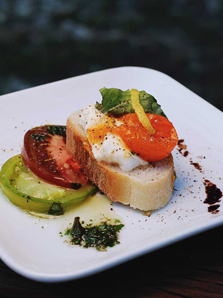 Burrata salad on crouton with flavored oil presented as an appetizer