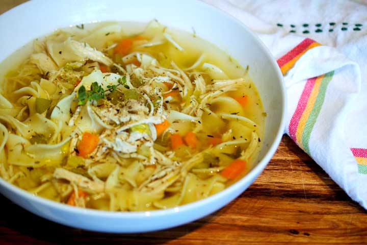 chicken noodle soup in bowl with napkin