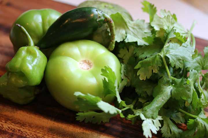 ingredients for salsa verde including peppers, tomatillos and cilantro
