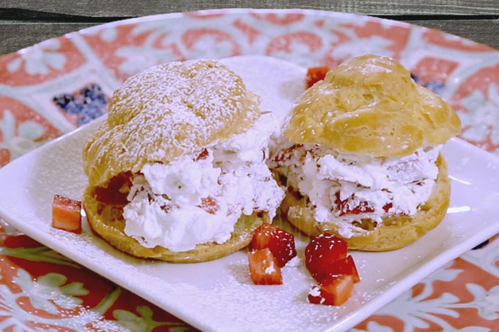 Sprinkling sugar over strawberry cream puffs